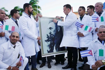 Các bác sĩ Cuba cầm di ảnh cố Chủ tịch Fidel Castro trong buổi lễ chia tay đoàn hỗ trợ y tế sang Italy giữa đại dịch Covid-19 tại Havana hồi tháng 3/2020. Ảnh: Reuters
